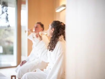 a bride and groom drinking wine in their wedding robes at Hof Weissbad Health & Wellness Resort in Weissbad