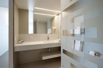 a bathroom with a sink and a large mirror at APPADU Appartements in St. Gallen