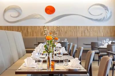 a dining room with a table with glasses and flowers at APPADU Appartements in St. Gallen