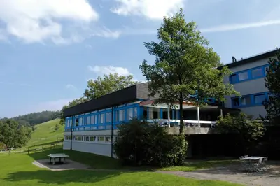 a building with a tree in front of it at St. Gallen Youth Hostel in St. Gallen