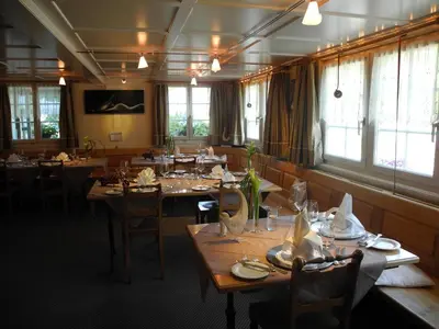 a dining room with tables and chairs and windows at Landgasthaus Bären in Grub