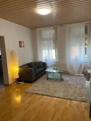 a living room with a couch and a table at room service Joppich in St. Gallen