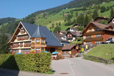 a large house in a village with a mountain at Gasthaus Schäfli in Alt Sankt Johann