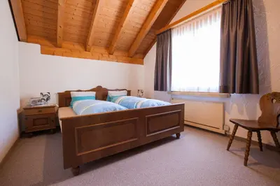 a bedroom with two beds and a window at Hotel Restaurant Schönau in Wildhaus