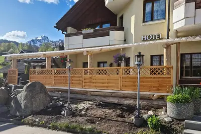 a hotel with a wooden fence in front of it at Hotel Restaurant Schönau in Wildhaus