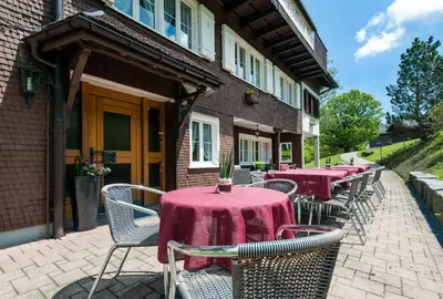 a group of tables and chairs on a patio at Schwendi Lodge in Unterwasser