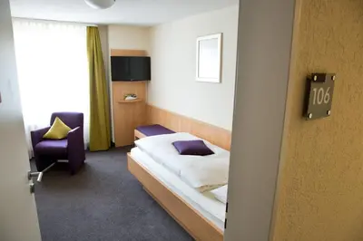 a hotel room with a bed and a chair at Hotel Buchserhof in Buchs