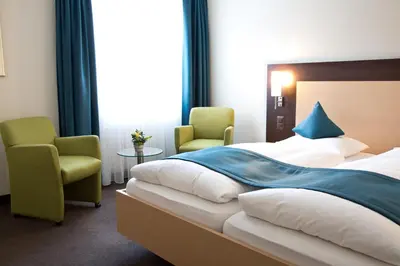 a hotel room with a bed and two chairs at Hotel Buchserhof in Buchs