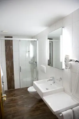 a white bathroom with a sink and a shower at Hotel Buchserhof in Buchs