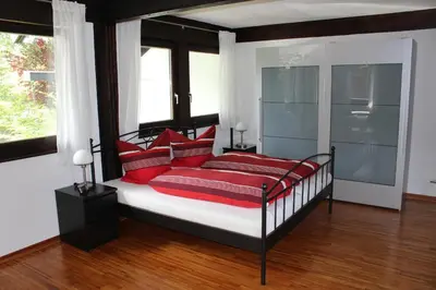 a bedroom with a bed with red pillows at Studio zum Wohlfühlen in Kreuzlingen