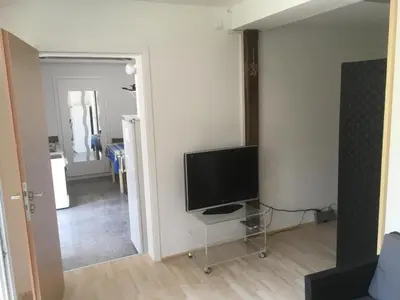 a living room with a flat screen tv in a room at Bodensee Moosburg Biohof am See in Güttingen