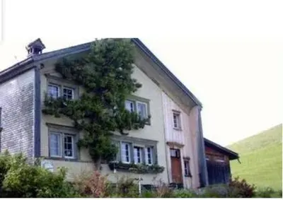 a house with a tree growing on the side of it at Ferienhaus Brand in Gais