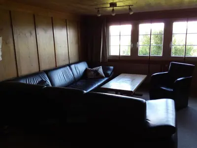 a living room with a couch and a table and windows at Ferienhaus Brand in Gais