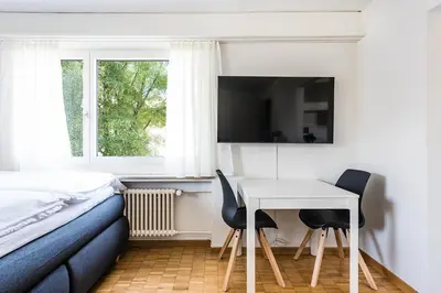 a bedroom with a bed and a table and chairs at SOHO 2A !Gratis Parken, Free Parking! in Kreuzlingen