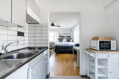 a white kitchen with a sink and a bedroom at SOHO 2A !Gratis Parken, Free Parking! in Kreuzlingen