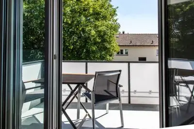a table and a chair sitting on a balcony at SOHO 2A !Gratis Parken, Free Parking! in Kreuzlingen