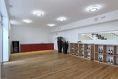 a large room with wooden floors and shelves with wine bottles at Gasthof Eisenbahn in Weinfelden