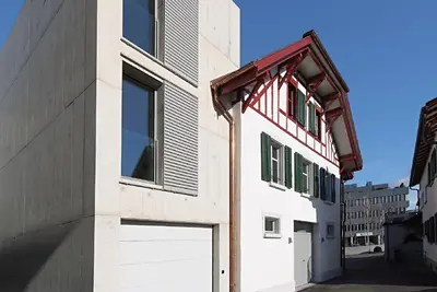 a white building with a red roof at Gasthof Eisenbahn in Weinfelden