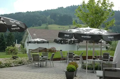 a patio with tables and chairs and umbrellas at Landgasthof Sternen in Bühler