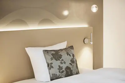 a bedroom with a bed with a pillow on it at Hotel Uzwil in Uzwil