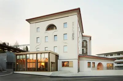 a large white building with glass windows at Hotel Uzwil in Uzwil