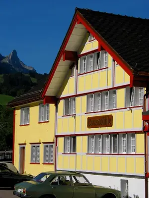 a building with a car parked in front of it at Loosmühle in Weissbad