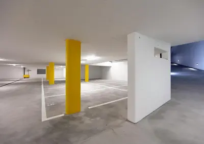 an empty parking lot with yellow poles in a parking garage at Lodge Hof Weissbad in Weissbad