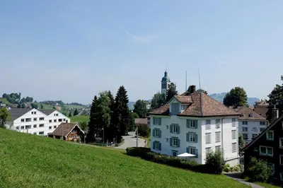 a white house on a hill in a village at Haus zur Rose, St.Gallen, Bodensee, Säntis in Speicher
