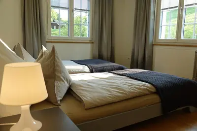 a bedroom with a bed and a vase with flowers at Haus zur Rose, St.Gallen, Bodensee, Säntis in Speicher