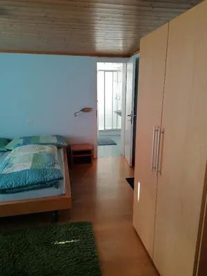 a bedroom with a bed and a large wooden cabinet at Gasthaus Bären Schlatt in Appenzell