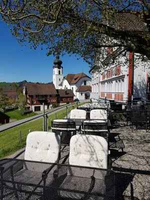 a group of tables and chairs with a lighthouse in the background at Gasthaus Bären Schlatt in Appenzell