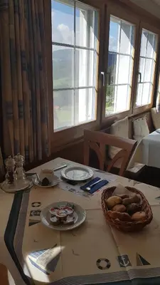 a table with plates of food and a basket of bread at Gasthaus Bären Schlatt in Appenzell