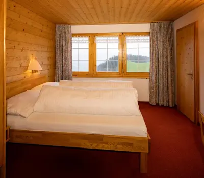 a bedroom with a large bed in a wooden room at Hotel und Restaurant Chäseren in Schönengrund