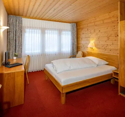a bedroom with a bed in a wooden room at Hotel und Restaurant Chäseren in Schönengrund