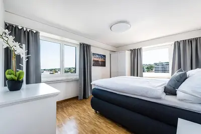 a bedroom with a large bed and two windows at SOHO 8 !Lake-Mountain View & Free Parking! in Kreuzlingen