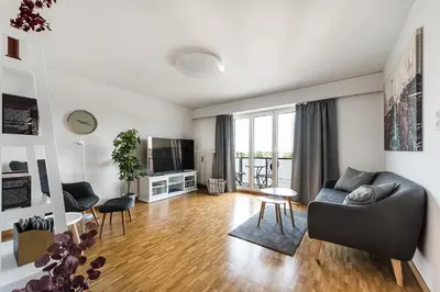 a living room with a couch and a television at SOHO 8 !Lake-Mountain View & Free Parking! in Kreuzlingen