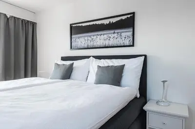 a bedroom with a white bed and a picture on the wall at SOHO 8 !Lake-Mountain View & Free Parking! in Kreuzlingen