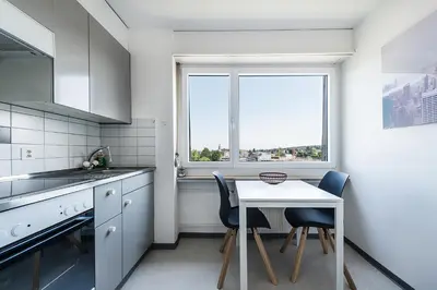 a kitchen with a table and chairs and a window at SOHO 8 !Lake-Mountain View & Free Parking! in Kreuzlingen