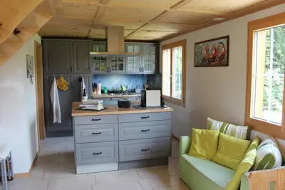 a kitchen with a counter and a couch in a room at Chalet Nueschwendi in Ebnat