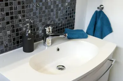 a white bathroom sink with a blue towel on it at Bella Vista in Wildhaus
