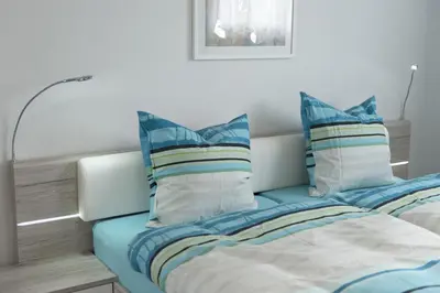 a bedroom with two beds with blue and white pillows at Bella Vista in Wildhaus