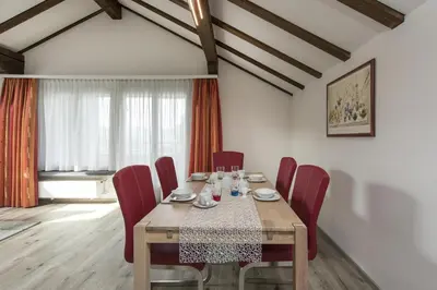 a dining room with a table and red chairs at Bella Vista in Wildhaus