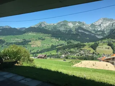a view of a green field with mountains in the background at Jizerka in Unterwasser