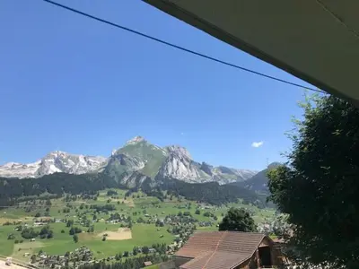 a view of a green field with mountains in the background at Jizerka in Unterwasser