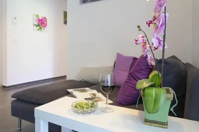 a coffee table with a vase of flowers and a glass of wine at Sunnewies in Wildhaus