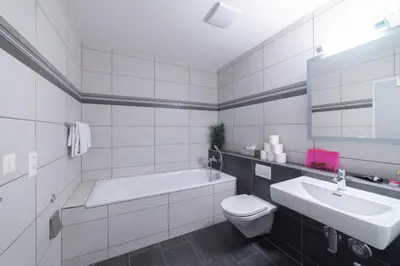 a bathroom with a tub and a toilet and a sink at Sunnewies in Wildhaus