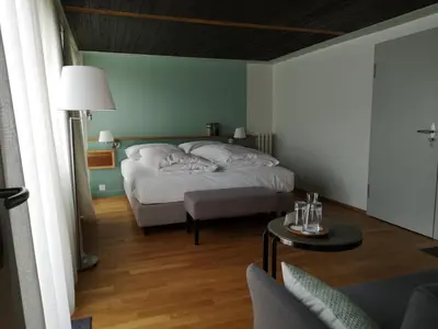 a bedroom with a bed and a living room at Gasthaus Friedegg in Wildhaus