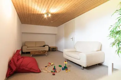 a living room with a couch and a chair at Steinrüti in Wildhaus