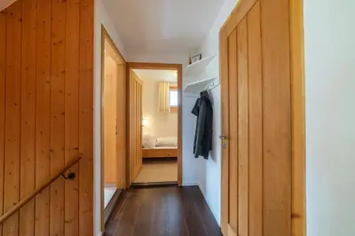 a hallway with wooden doors and a bedroom at Steinrüti in Wildhaus