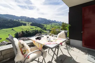 a table and chairs on a balcony with a view at Steinrüti in Wildhaus